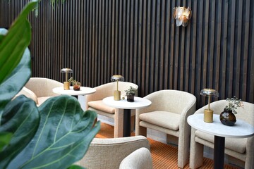 A cozy place with small round tables and white chairs.