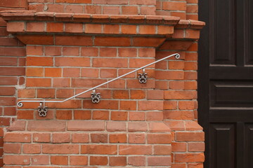 wrought iron railings on a red brick wall