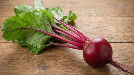 A red beetroot is sitting on a wooden table