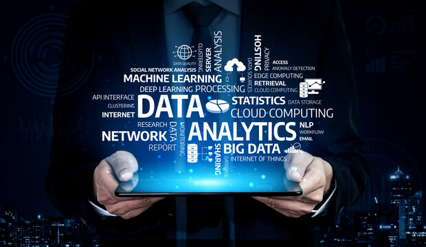 A businessman holds a tablet showcasing data analytics, with technology-related words prominently displayed, symbolizing cloud computing and big data concepts. Tessel - Powered by Adobe