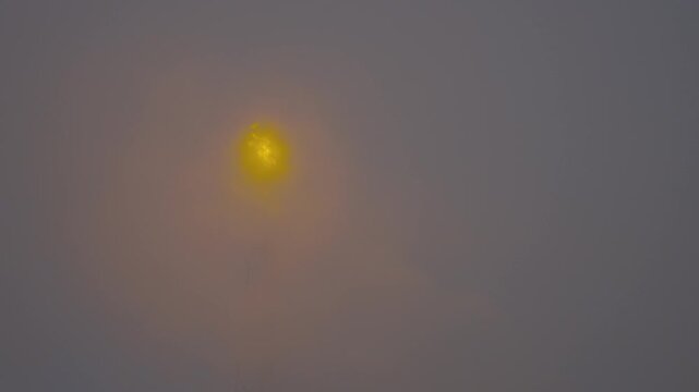 Industrial chimney flaring off excess gas in fog.