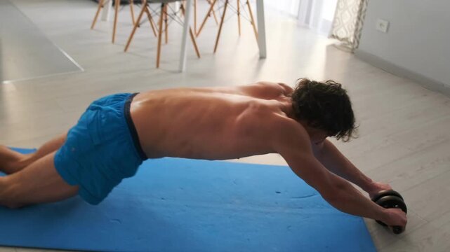 Controlled core movement on blue surface, Athlete performing precise extension drill with focused breathing, Smooth transition from kneeling to full stretch on mat emphasizing strength and