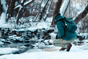 guy feeds a bird in the snow