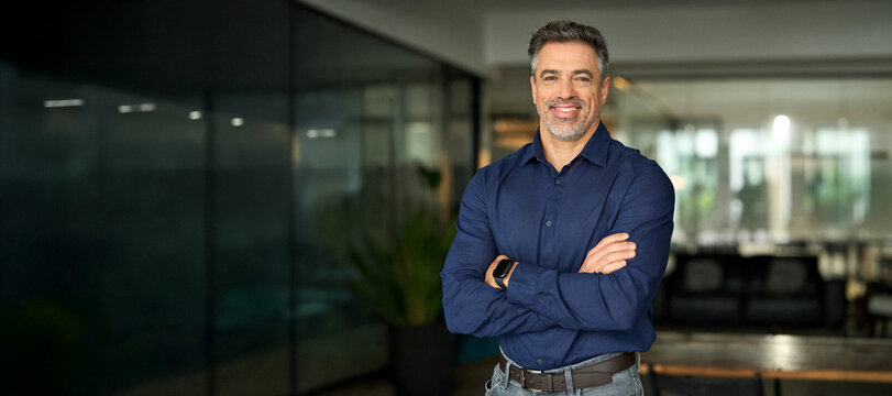 Smiling mature 50 years old business owner, company manager, smiling senior ceo executive, older corporate leader at work. Happy professional business man of middle age standing in office. Portrait.