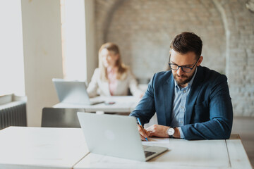 Diverse business people working at their desks in a modern open-plan office.
