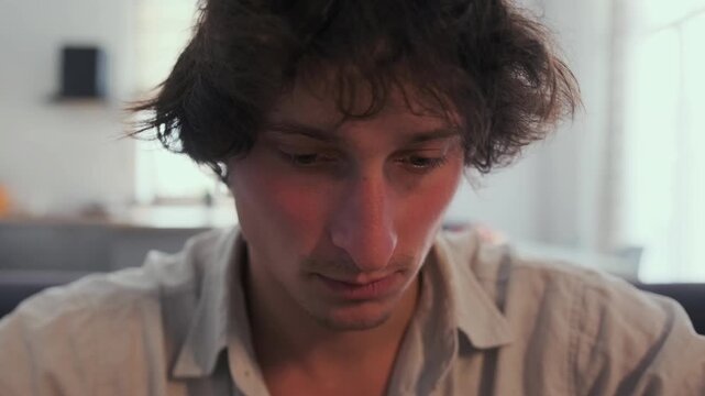 caucasian man closeup portrait with introspective expression, gentle natural light, slightly tousled hair, direct and vulnerable gaze, quiet moment of self reflection in cozy living room