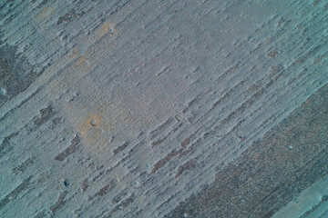 Scratched blue grey grunge texture resembling weathered concrete or old metal surface abstract background top down aerial drone shot