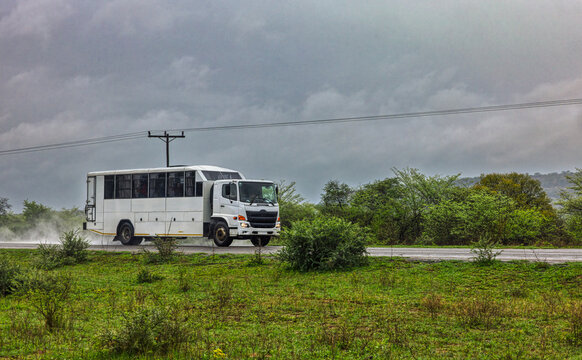 Remote Access Vehicle RAV converted bus body , on an open road in the heavy rain storm, transporting people personnel .