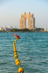Fototapeta premium Line of yellow buoys leading to Rixos Marina Abu Dhabi hotel at sunset