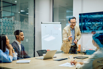 Business man presenting ideas and solutions to a diverse, engaged team during a corporate meeting in a modern office