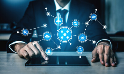A businessman in a suit interacts with a tablet featuring digital network connections. This image represents technology integration, innovation, and modern business solutions. Tessel