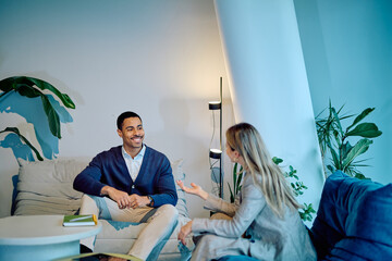 Business colleagues having a relaxed conversation in a contemporary office lounge area, smiling and interacting during a meeting