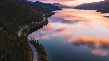 Aerial view of a winding road by a lake at sunset