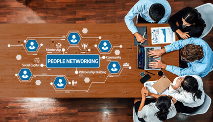 Top view of a diverse group of professionals collaborating in a modern office environment, emphasizing relationship building and networking with digital elements for effective teamwork. Amity