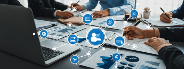 A dynamic business meeting showcasing teamwork and data analysis in a modern office. Collaborative efforts are highlighted through digital connectivity and professional engagement. Amity