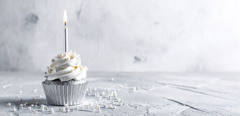 Minimalist Silver Cupcake with White Pearl Sprinkles and Candle on Grey Background
