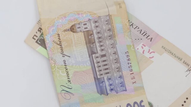 Ukrainian 500 Hryvnia banknotes on white background. This footage is ideal for projects related to finance, economy, wealth, or banking.