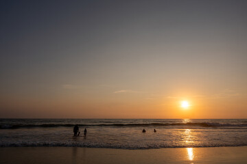 Obraz premium Silhouette of a family enjoying the sunset on the beach. Family tourism beach. Costa Grande, costalegre.