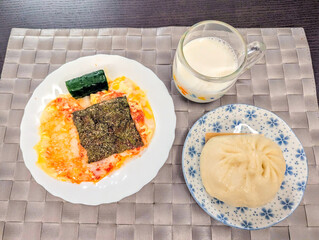 とろけるチーズとケチャップをのせた餅と肉まんの朝食