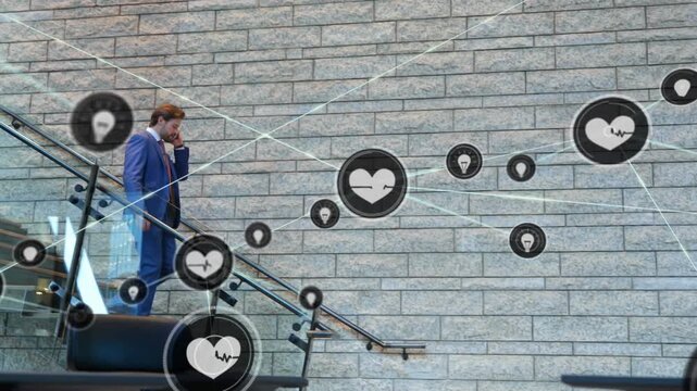 Man descending glass steps on call as floating icons forming network moving over him for business
