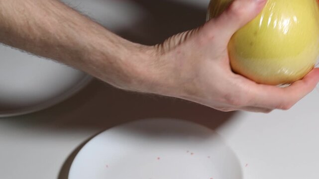 Close-up of hands meticulously unwrapping a bright, yellow pomelo from its protective plastic, getting ready to use it as a fresh and healthy food snack