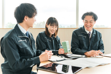 Fototapeta premium Male and female businessmen in work clothes having a meeting while looking at a model of a building