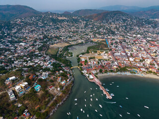 Fototapeta premium Aerial view of the port and bay of Zihuatanejo in Costa Grande, Guerrero. Boats and tourist pier. Zihuatanejo, Guerrero, Mexico. Ixtapa
