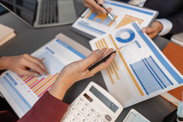 Business professionals reviewing financial charts and performance reports during a meeting,...