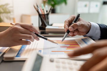 A business meeting scene where professionals review financial charts and exchange insights, highlighting strategic planning and collaborative decision making in a modern office environment.