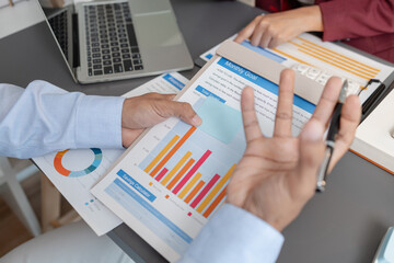 Business colleagues reviewing budget charts together in a modern office, focusing on financial...