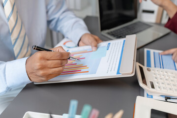 Business colleagues reviewing budget charts together in a modern office, focusing on financial insights, performance metrics, and strategic planning to support upcoming business decisions.