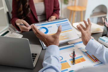 Business colleagues reviewing budget charts together in a modern office, focusing on financial...