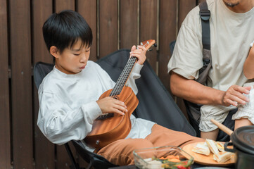 Elementary school boy playing ukulele