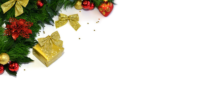 Festive Christmas background featuring an evergreen garland decorated with red and gold ornaments, glitter bows, and holiday accents along the top edge. The clean white copy space below makes it ideal