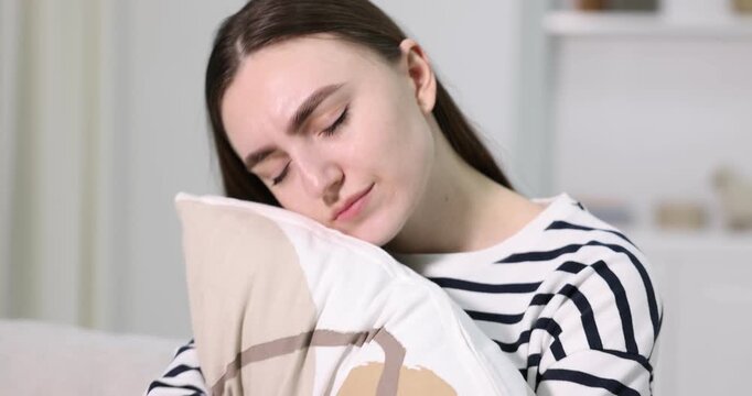 Woman with pillow feeling fatigue at home, camera moving in