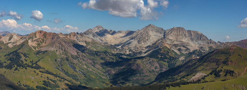 This stunning Elk Range Mountain panorama features Colorado 14ers Capitol Peak and Snowmass Mountain rising above lush green Lead King Basin.