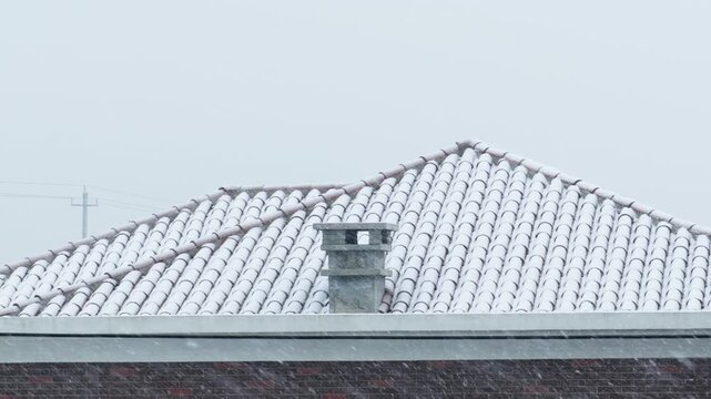 Snow-Covered Roof with Ceramic Tiles and Chimney in Winter Countryside