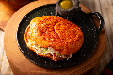 Pambazos. Mexican sandwich marinated in red sauce and roasted on a comal traditionally stuffed with potatoes and chorizo, a classic of Mexico City street food.