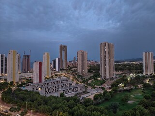 Fototapeta premium urban twilight with lit windows, serene evening view of city buildings and natural surroundings