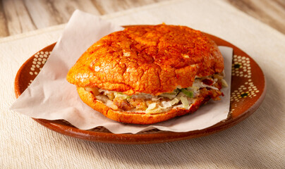 Pambazos. Mexican sandwich marinated in red sauce and roasted on a comal traditionally stuffed with potatoes and chorizo, a classic of Mexico City street food.