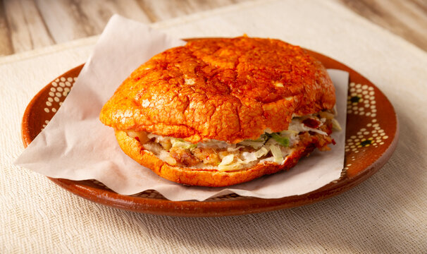 Pambazos. Mexican sandwich marinated in red sauce and roasted on a comal traditionally stuffed with potatoes and chorizo, a classic of Mexico City street food.