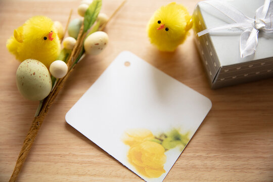 An Easter holiday thank you card desktop display with fuzzy yellow baby chicks, a notecard, a silver gift box and easter eggs.  The tulip notecard is my photography printed.