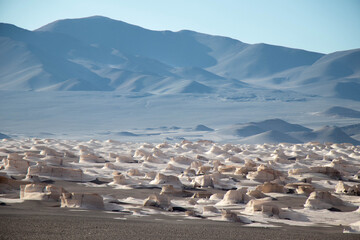 Daytime View of Pumice Stone Field Landscape with mountains in the background in Catamarca,...