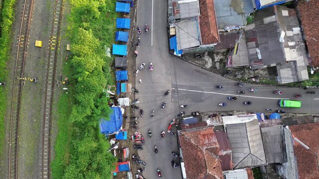 Smooth Ascending Drone Shot of Busy Urban Intersection Near Railway with Stable Aerial Motion
