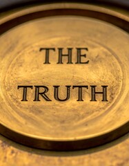 Bronze disc with etched words "THE TRUTH" against warm, textured background