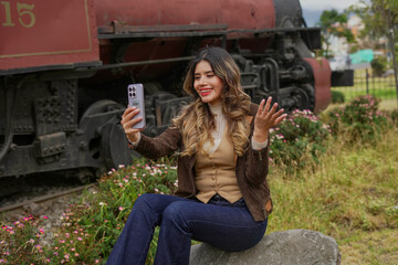 Smiling woman making video call with phone near train © Martin Stock Studio