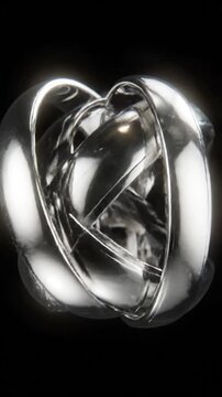 Close-up of three gleaming, reflective silver metal rings interlocked on a dark background
