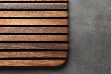 Close Up of Wooden Slat Board on Textured Gray Pavement Outdoors with Horizontal Stripes and Neutral Colors in Overhead Shot