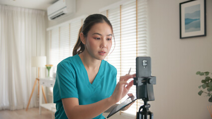 Young adult woman asia Gen Z people anti aging expert modern nurse live talk prepare video selfie camera on mobile phone app mental health care Online side hustle digital virtual asian vlogger filming