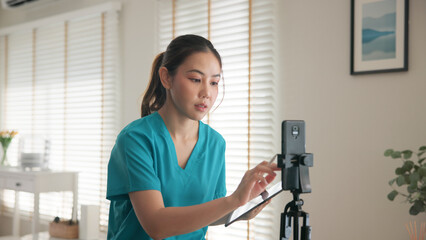 Young adult woman asia Gen Z people anti aging expert modern nurse live talk prepare video selfie camera on mobile phone app mental health care Online side hustle digital virtual asian vlogger filming